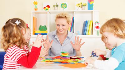 Vier kinderen en een behandelaar praten met elkaar